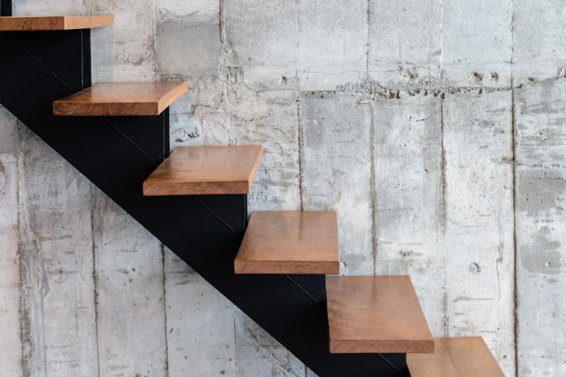 Montaż stopni drewnianych na schodach betonowych – wykończenie betonowych stopni drewnianymi elementami.